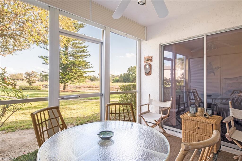 5451 Rattlesnake Hammock Road, Unit D108 Naples, FL 34113 - Photo 2 of 17 a living room with furniture and floor to ceiling windows