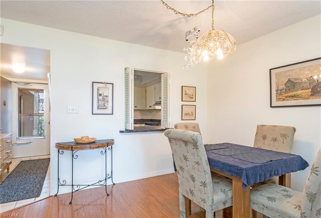 5451 Rattlesnake Hammock Road, Unit D108 Naples, FL 34113 - Photo 6 of 17 a view of a dining room with furniture and wooden floor