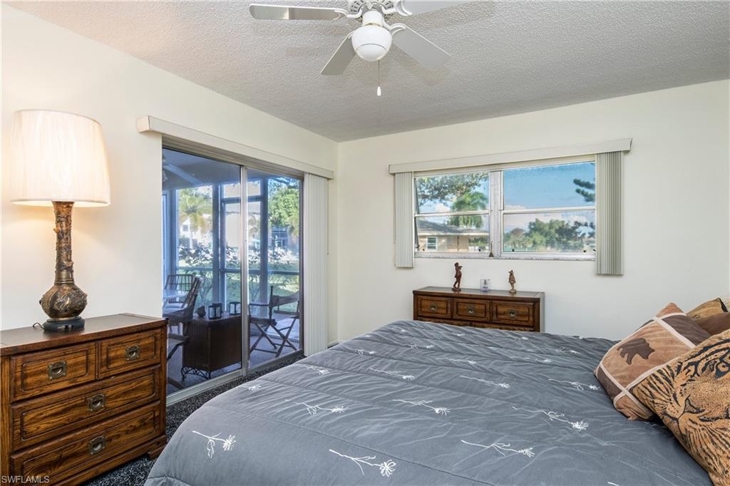 5451 Rattlesnake Hammock Road, Unit D108 Naples, FL 34113 - Photo 9 of 17 a bedroom with a bed and wooden floor