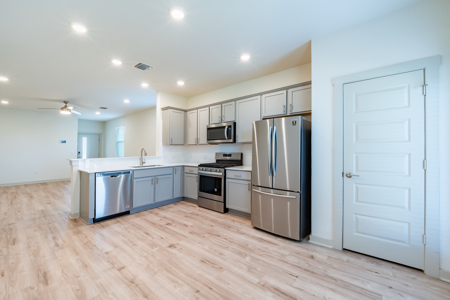 10801 Meris Lane Austin, TX 78754 - Photo 7 of 18 Modern kitchen with stainless steel appliances and durable wood-look flooring.
