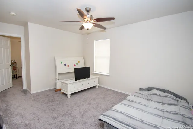 a bedroom with bed and ceiling fan