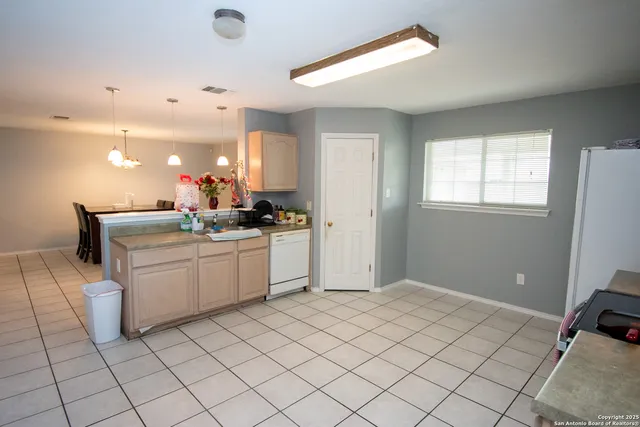 a room with a chair and white cabinets