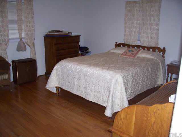 2109 East Charlotte Court Raleigh, NC 27607 - Photo 6 of 9 a bedroom with a bed and a dresser
