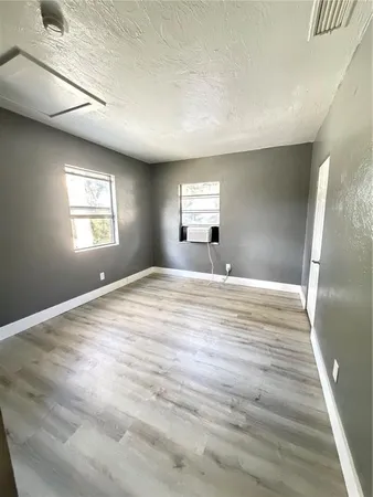 a view of empty room with wooden floor