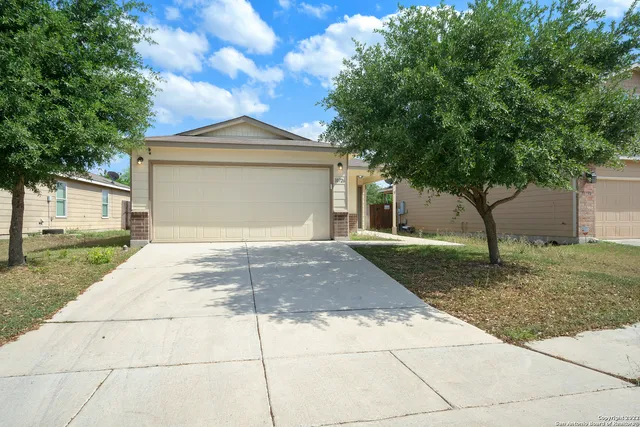 a front view of a house with a yard and trees