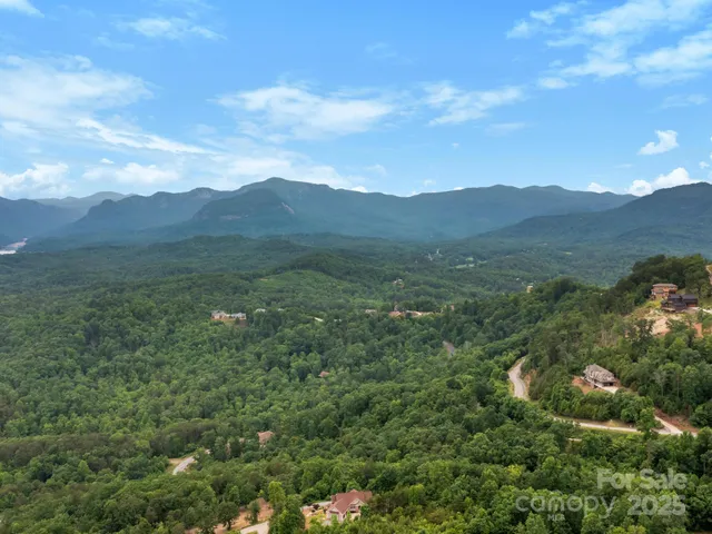 a view of an empty room with window and a kitchen view
