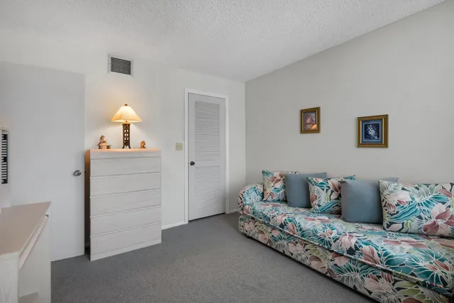 a view of a lake with a yard and large trees