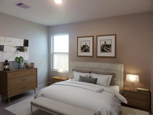 a bedroom with a bed and a lamp on dresser