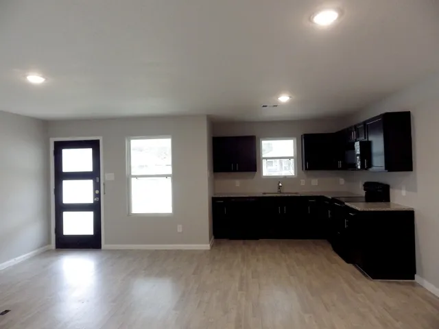 a kitchen with granite countertop a sink and cabinets