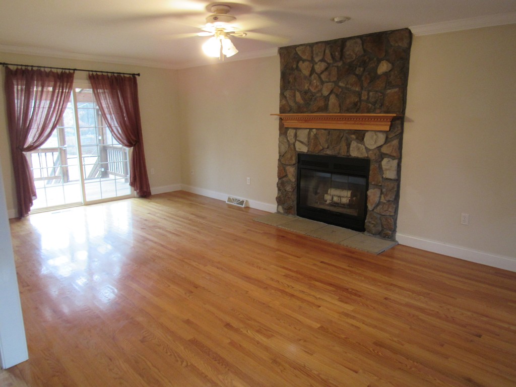 63 Valley Road Southampton, MA 01073 - Photo 3 of 18 an empty room with wooden floor fireplace and windows