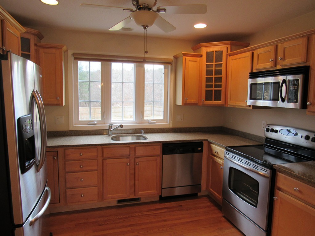 63 Valley Road Southampton, MA 01073 - Photo 9 of 18 a kitchen with stainless steel appliances granite countertop a stove a sink dishwasher a refrigerator and wooden cabinets