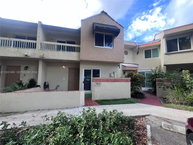 a front view of a house with plants