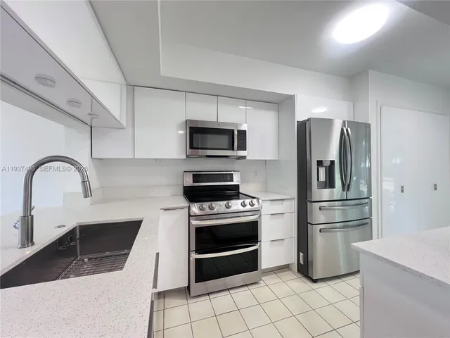 a kitchen with stainless steel appliances granite countertop a refrigerator stove and sink