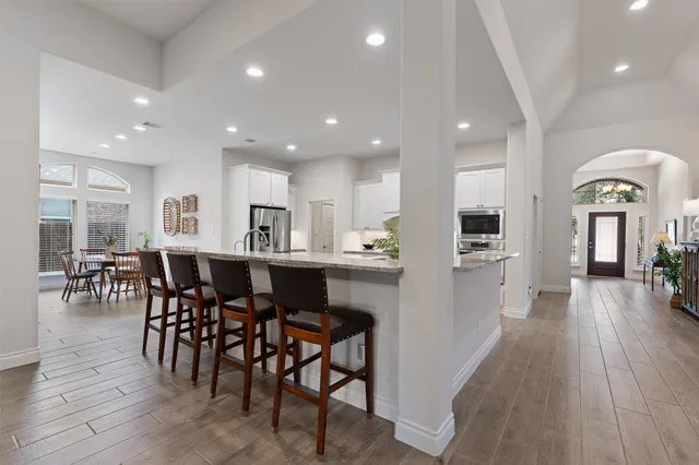 a view of kitchen with dining table stainless steel appliances refrigerator dining table and chairs