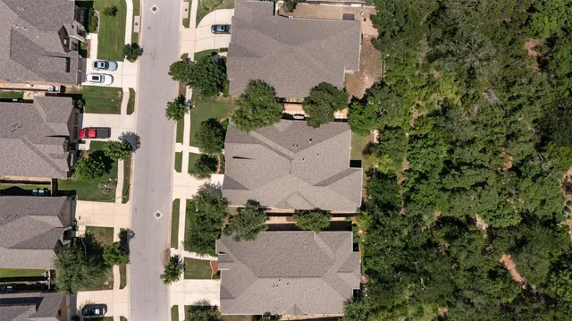 an aerial view of a house with a yard and parking