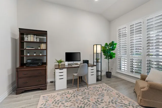 a view of a workspace with furniture and a window