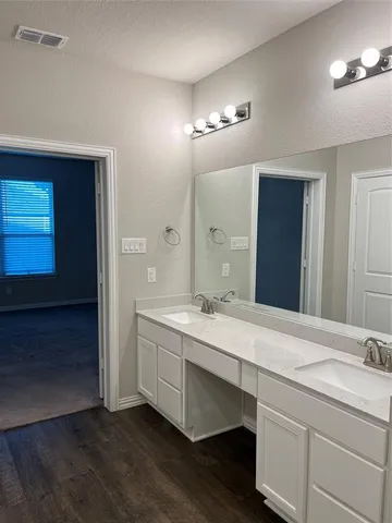 a bathroom with a double vanity sink and a mirror