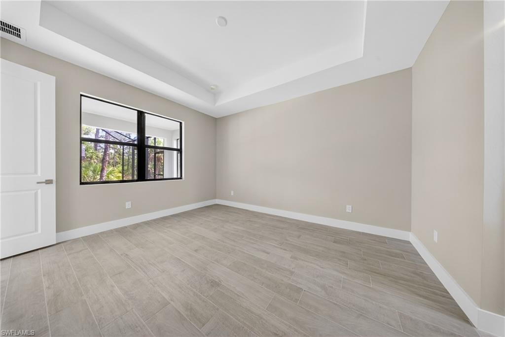 18 Scott Avenue Lehigh Acres, FL 33936 - Photo 18 of 37 wooden floor in an empty room with a window