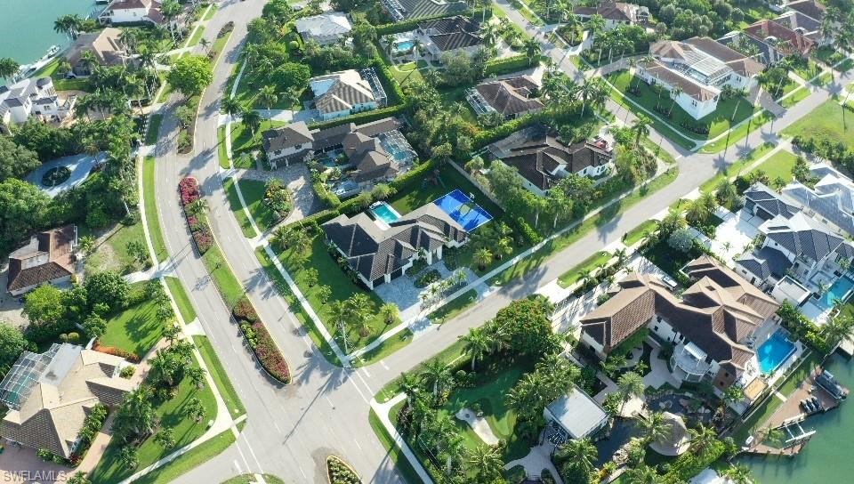 1702 Ludlow Road Marco Island, FL 34145 - Photo 8 of 47 Aerial perspective of a developed residential area featuring multiple single-family homes with private swimming pools and mature landscaping