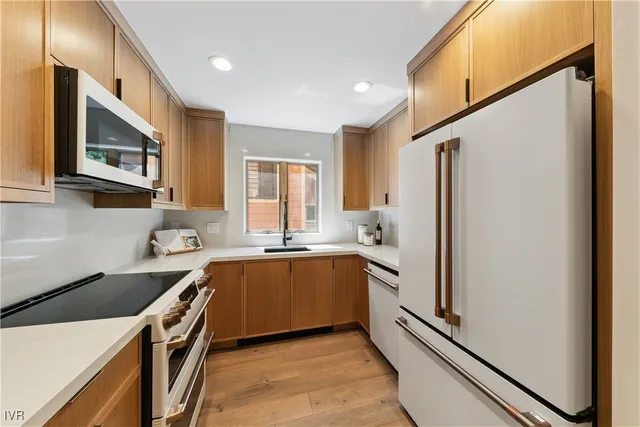 a kitchen with stainless steel appliances granite countertop a refrigerator and a sink