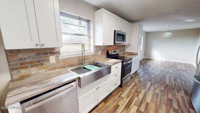 a kitchen with a sink a stove and cabinets
