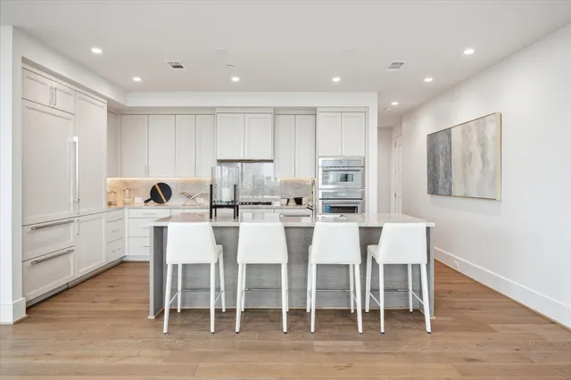 a dining room with furniture a chandelier and wooden floor