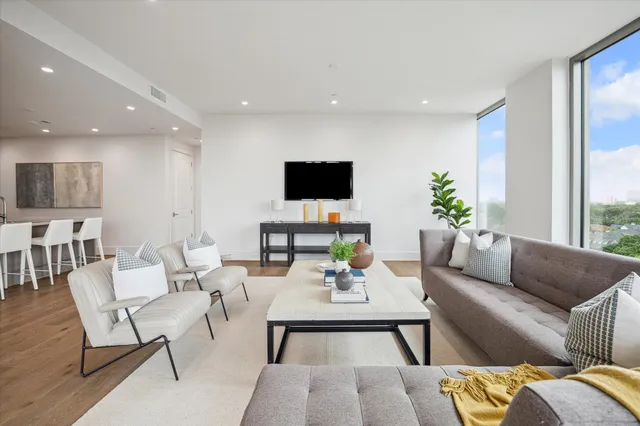 a spacious en suite bathroom with a double vanity sink a large mirror and a bathtub