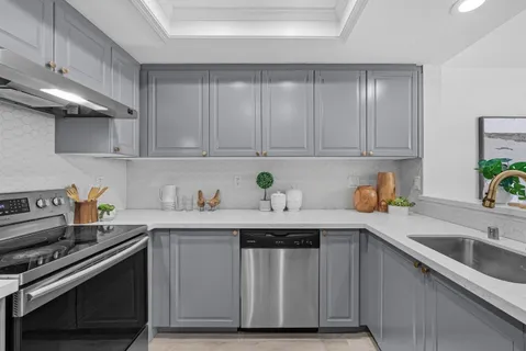 a kitchen with stainless steel appliances granite countertop a sink a stove and cabinets
