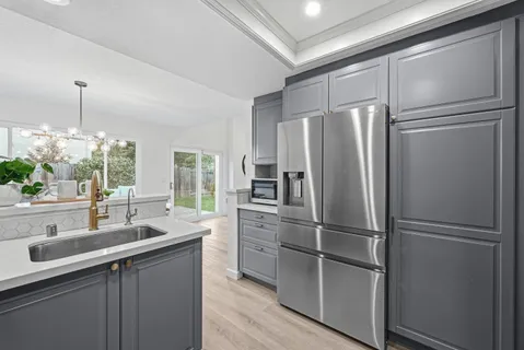 a kitchen with a refrigerator sink and cabinets