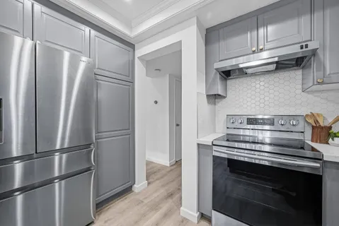 a metallic refrigerator freezer sitting inside of a kitchen