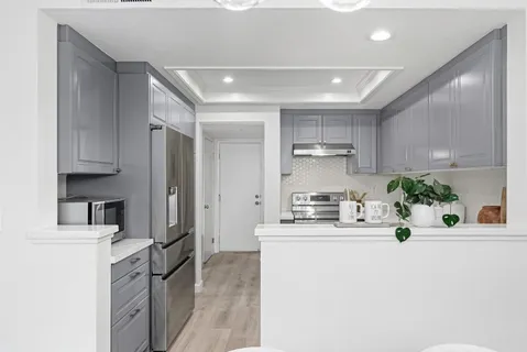 a kitchen with kitchen island a counter top space a sink stainless steel appliances and cabinets