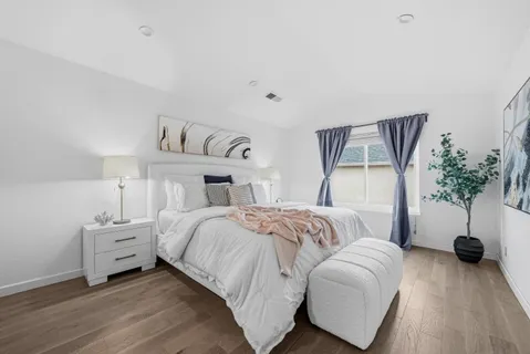a bedroom with a bed and a potted plant