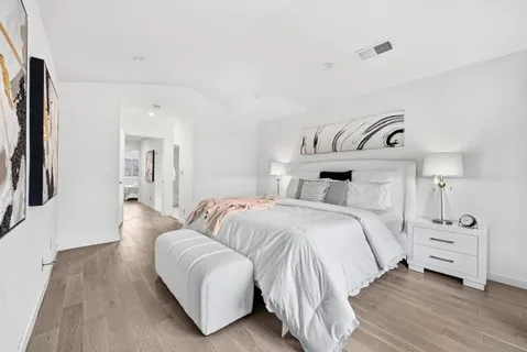 a bedroom with a bed and wooden floor