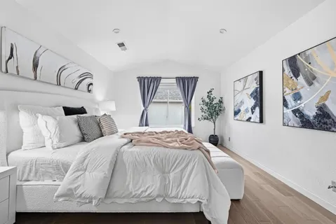 a bedroom with a large bed and paintings on the wall