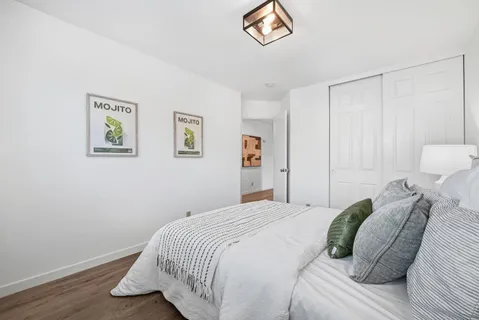 a bedroom with a bed and a painting on the wall