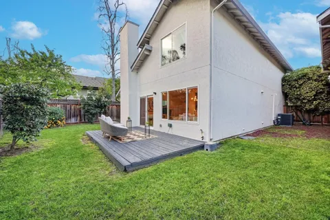 a view of a house with backyard and a tree