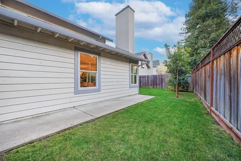 a view of a house with backyard and a garden