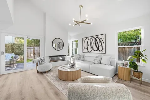 a living room with furniture a clock and a large window