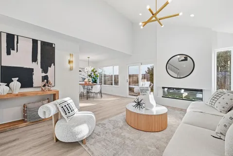 a living room with furniture a mirror and a large window