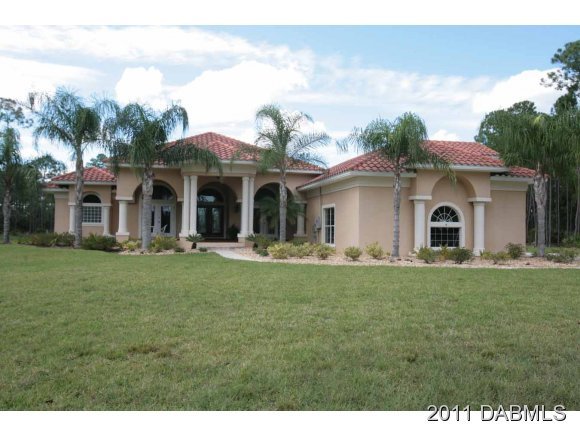 9 Remington Road Ormond Beach, FL 32174 - Photo 1 of 22 a front view of a house with a garden