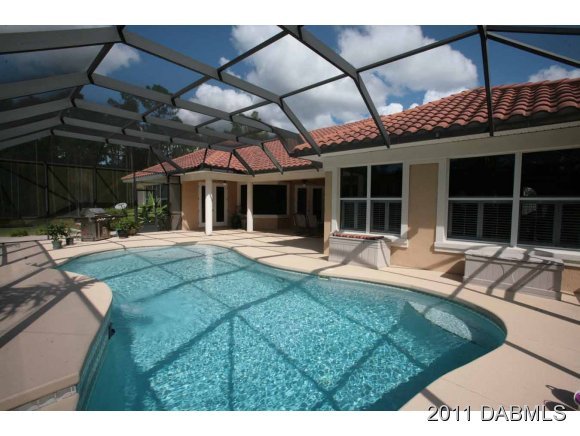 9 Remington Road Ormond Beach, FL 32174 - Photo 21 of 22 a view of a patio with a table and chairs under an umbrella