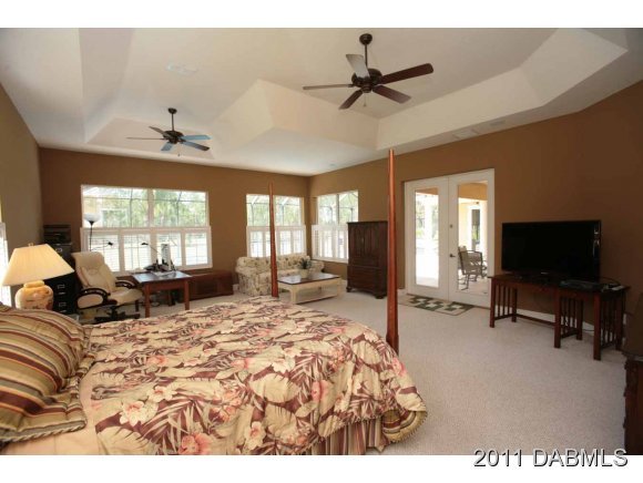 9 Remington Road Ormond Beach, FL 32174 - Photo 6 of 22 a large bedroom with a bed and a flat tv screen on dresser