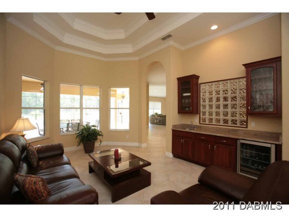 9 Remington Road Ormond Beach, FL 32174 - Photo 8 of 22 a living room with furniture a flat screen tv and a large window