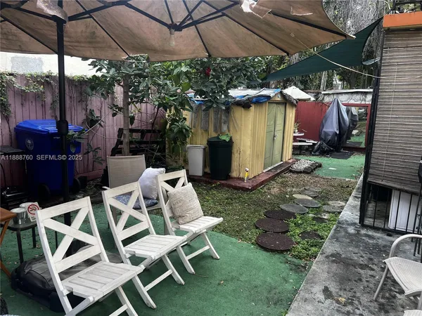 a view of a patio with table and chairs under an umbrella