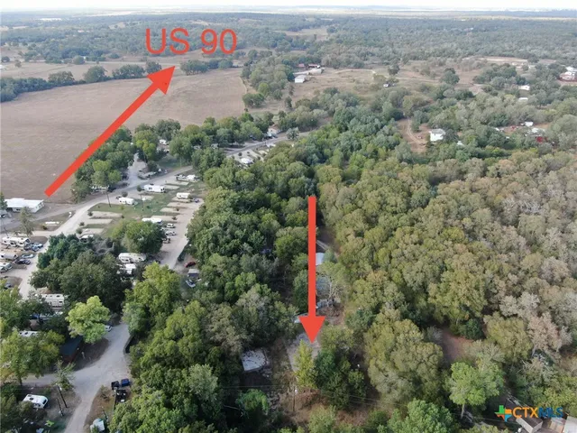 an aerial view of residential houses with outdoor space and trees