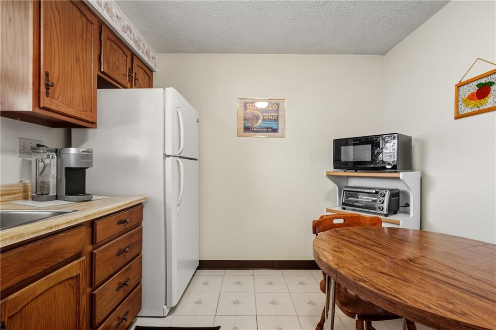 11 McKinley Square Coraopolis, PA 15108 - Photo 14 of 26 a kitchen with a table chairs refrigerator and a sink