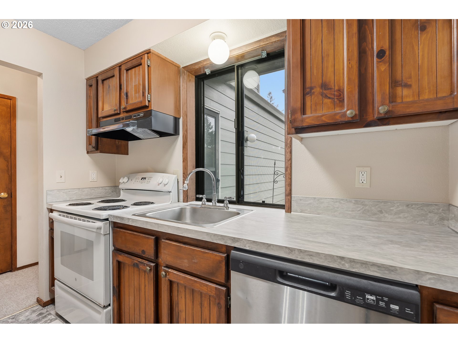 14807 Southwest 106th Avenue Portland, OR 97224 - Photo 14 of 37 a kitchen with stainless steel appliances granite countertop a sink stove and cabinets