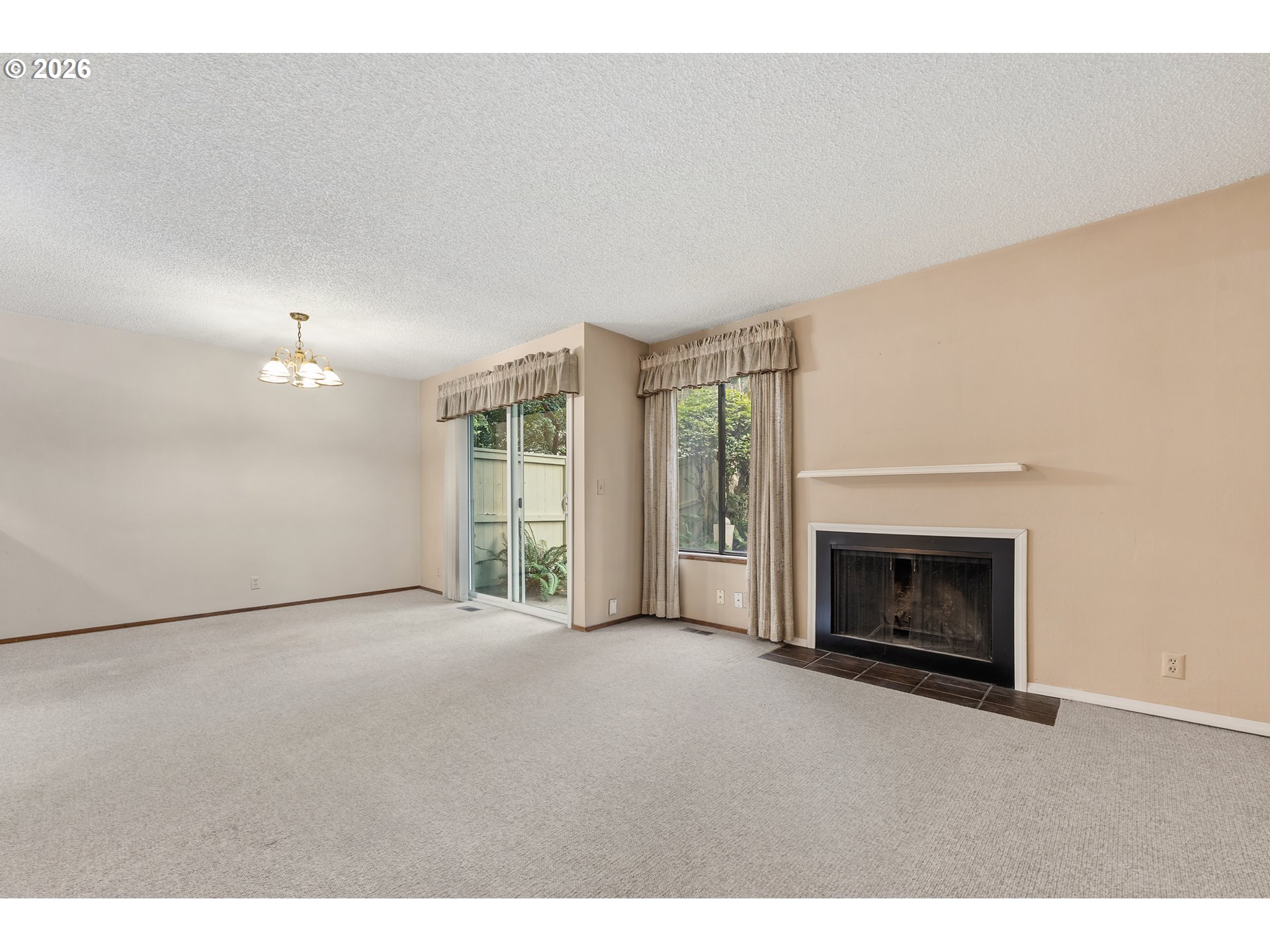 14807 Southwest 106th Avenue Portland, OR 97224 - Photo 5 of 37 a view of an empty room with a fireplace and a window