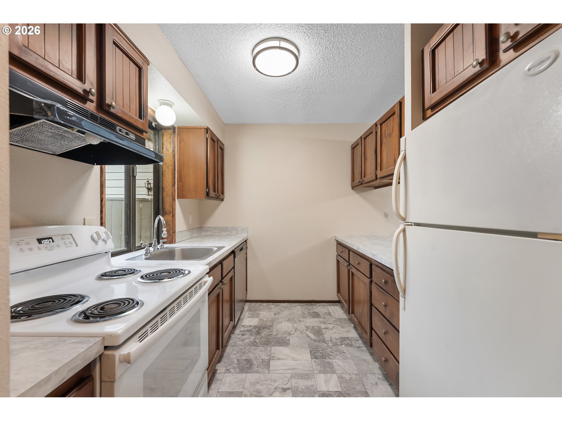 14807 Southwest 106th Avenue Portland, OR 97224 - Photo 10 of 37 a kitchen with a sink a stove and cabinets