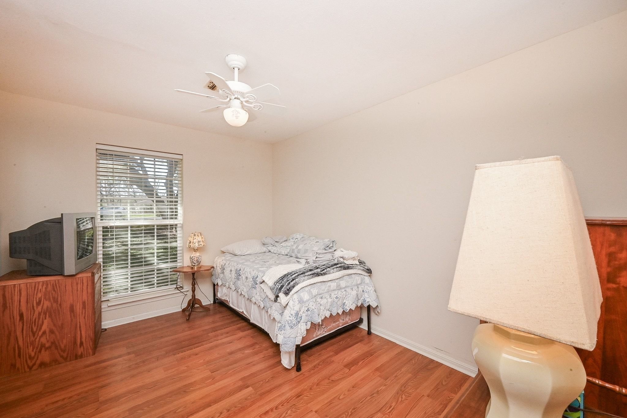 18910 Carrot Street Spring, TX 77379 - Photo 32 of 48 a bedroom with a bed and wooden floor
